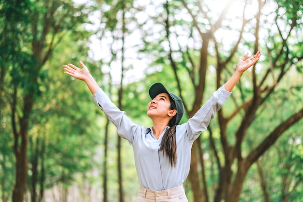 Photo asian women raise their hands to nature in the forest people protect from deforestation and pollution or climate change concept to love nature and tree environment ecology and earth day concept