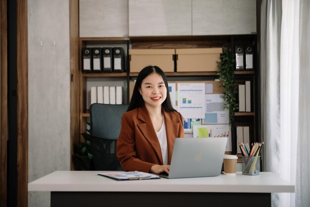 Photo asian young businesswoman working in the office with working notepad tablet and laptop documents