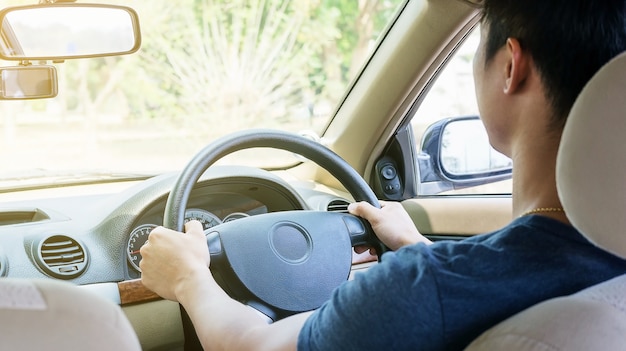 Photo アジアの若い男が車を運転します。