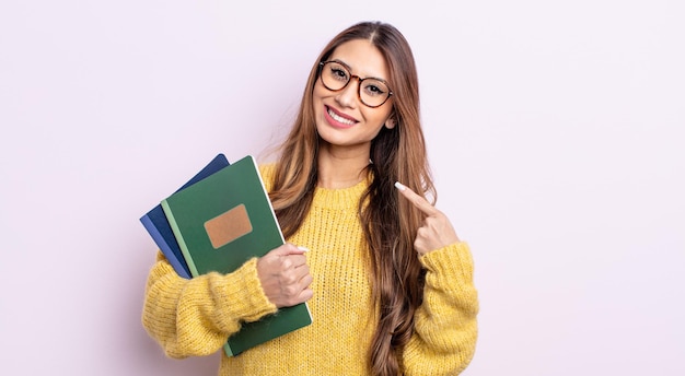 Photo asiatic pretty woman smiling confidently pointing to own broad smile. student concept