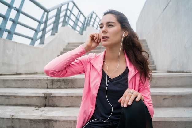 Athletic woman listening to music on a break from training.