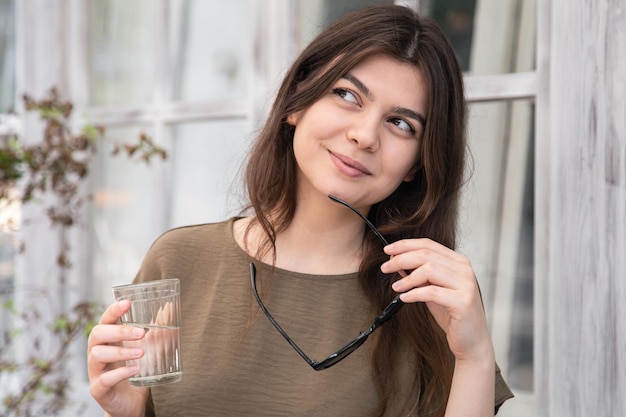 Attractive young woman with a glass of water with sunglasses