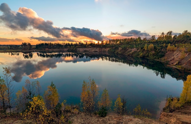 Autumn landscape with beautiful clouds over the lake at sunset. Leningrad region.