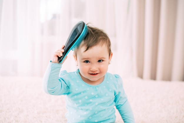 Baby with a comb a little girl with a blue comb comb combs her hair