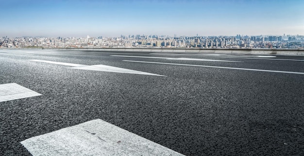 Background of asphalt pavement and urban architectural landscape skyline