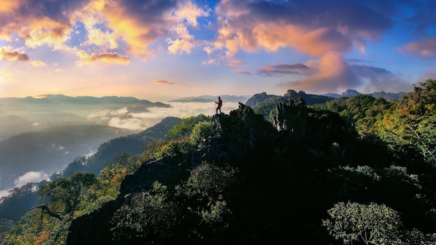 Backpacker standing on sunrise viewpoint at Ja Bo village, Mae hong son province, Thailand.