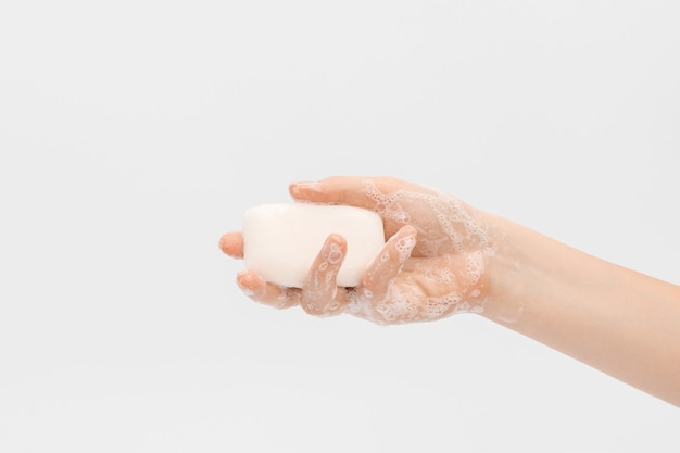 A bar of soap in soapy female hands.