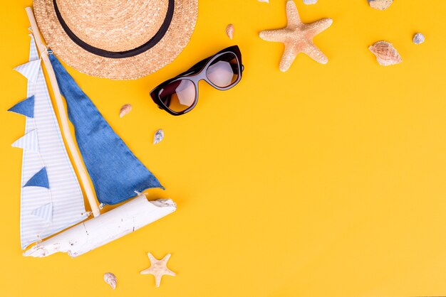 Photo beach accessories: glasses and hat with shells and sea stars.