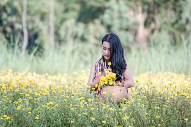 Beautiful asian gardener girl in marigold flowers field 