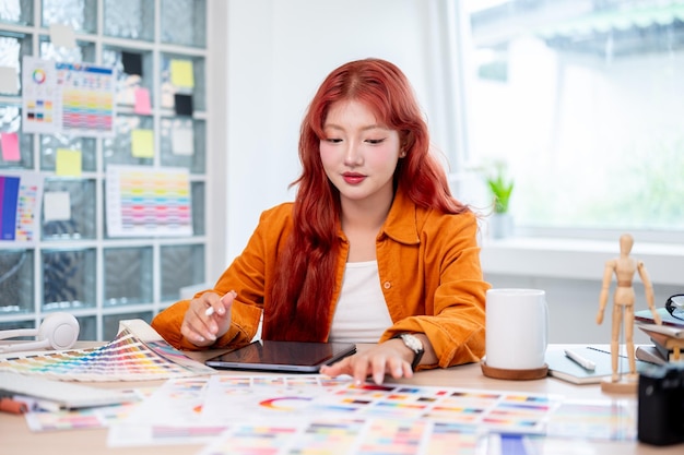 Photo a beautiful and creative asian female graphic designer is working at her desk in the studio