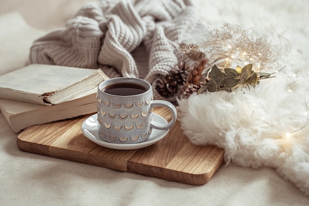 A beautiful cup with a hot drink on a wooden tray. Home comfort concept.