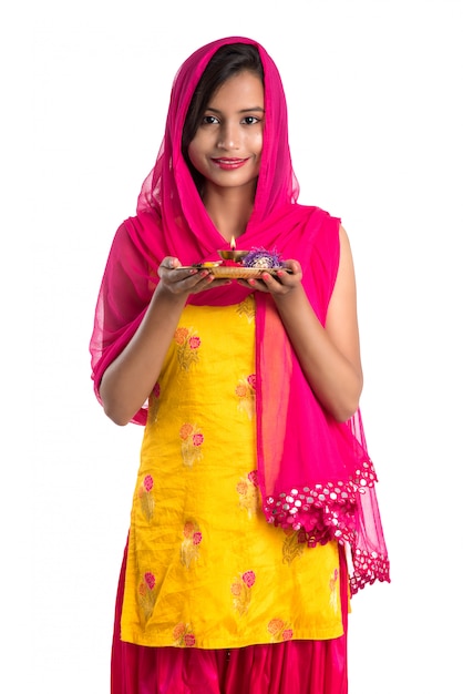 Beautiful Indian young girl holding pooja thali or performing worship