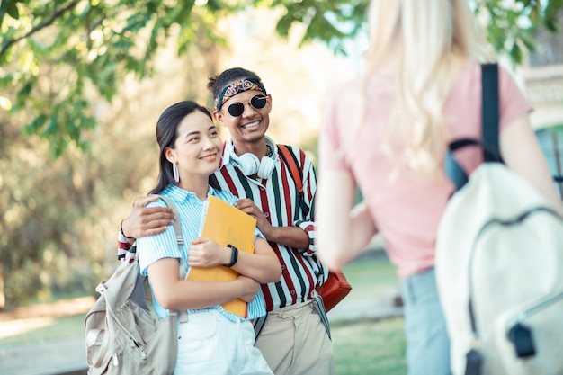 beautiful joyful couple of students going home together after university