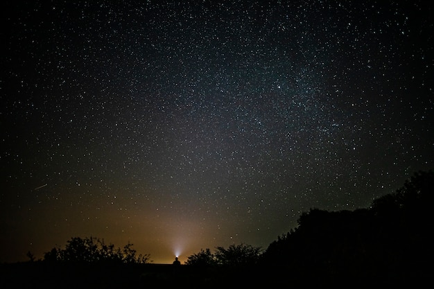 Beautiful long shot of a man sitting below sky