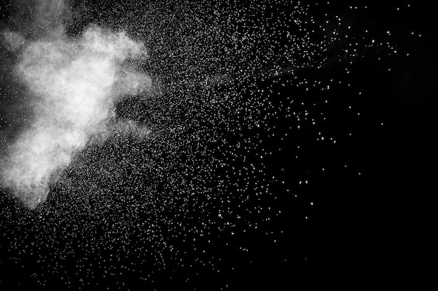 Bizarre forms of white powder explosion cloud against black background.White dust particles splash.