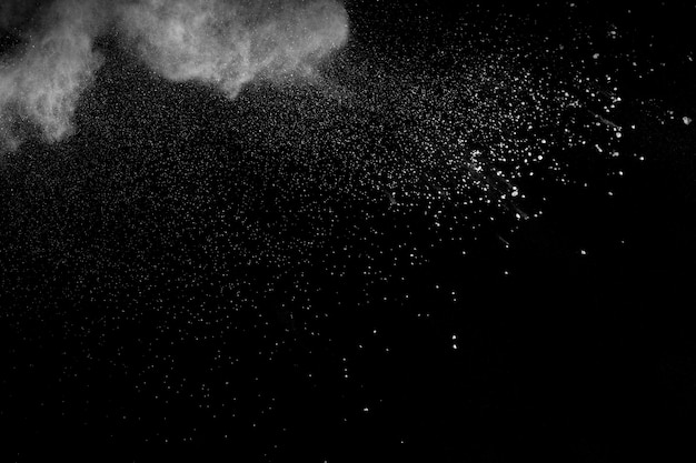 Bizarre forms of white powder explosion cloud against black background.White dust particles splash.