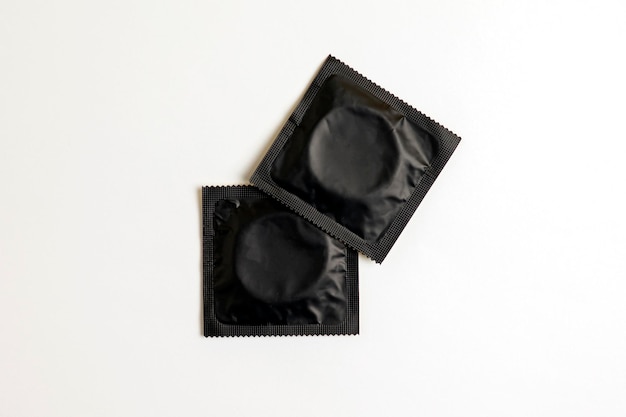 Photo black condom on white background top view safe sex concept