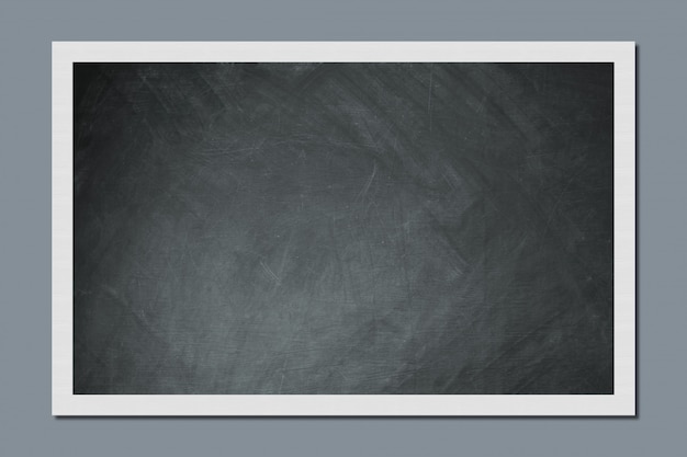 Blank chalkboard hangs on grey wall in classroom. Education and school concept. Empty space for your information or advertisement.