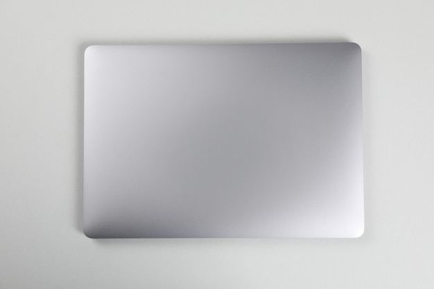 Blank close laptop on white table top view