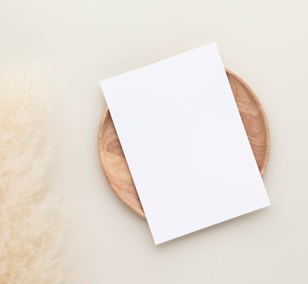 Photo blank paper cards, mockup with pampas grass on a wooden plate, beige background, minimal beige workplace composition, flat lay, mockup