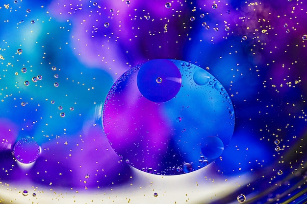 Blue background with oil circles . Bubbles of water. Close up.