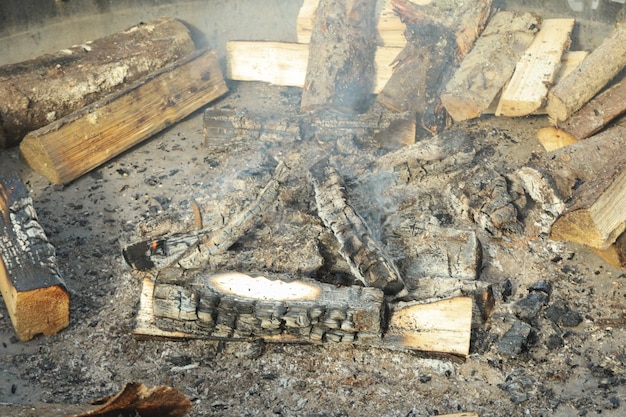 Bonfire with smoldering wood and firewood pieces