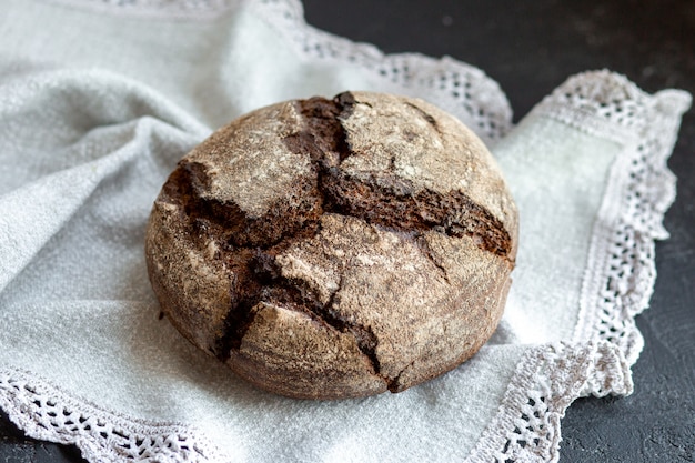 Bread in a basket with rolls. Fresh bakery. Beautifully folded black and white bread in a metal basket. Baking in a bread box.