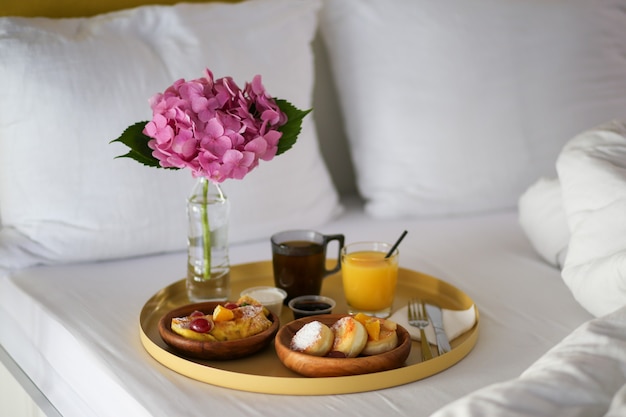 Breakfast in the hotel. Breakfast in bed with a flower. Coffee, juice and cheesecakes in bed. Eat in bed. Lazy weekend.