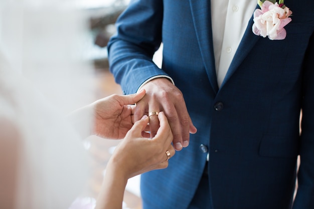 Photo bride puts ring on groom's finger