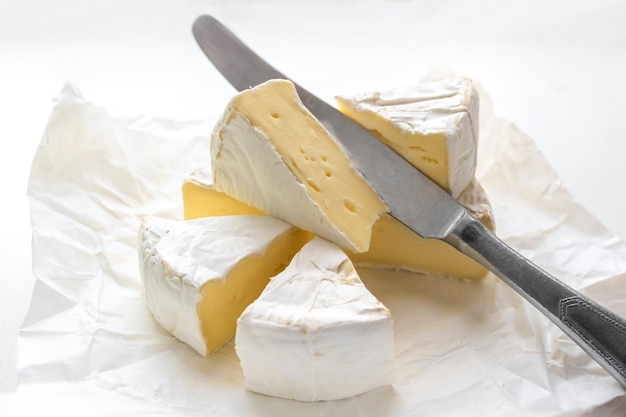 Photo brie cheese and kitchen knife in craft white paper