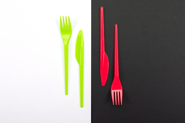 Bright green and red forks isolated on black and white background