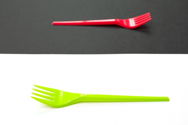 Bright green and red forks isolated on black and white background