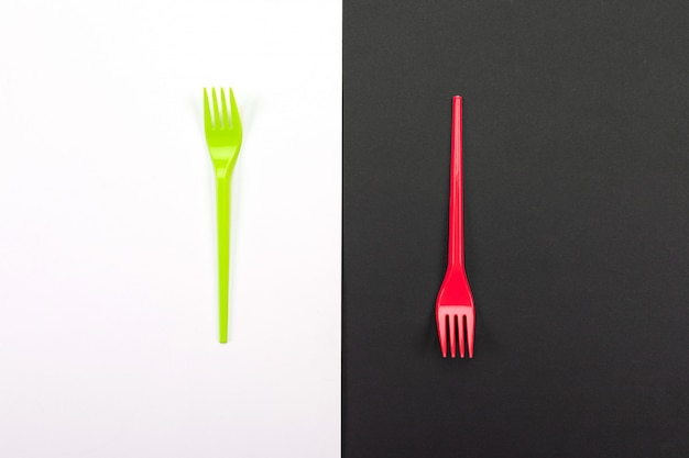 Bright green and red forks isolated on black and white 