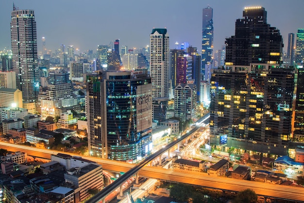 A Building in business area in the Bangkok at night with traffic jam.