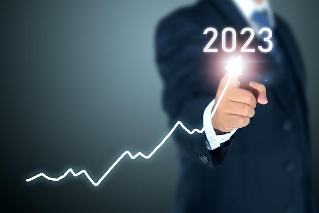 business man signing 2023 profit graph