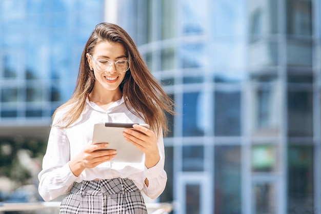 Business woman using tablet near modern business center.