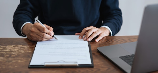 Businessman signing financial contract and signature after reaching agreement.