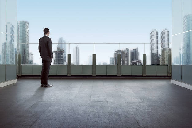 Businessman standing on a roof and looking at city