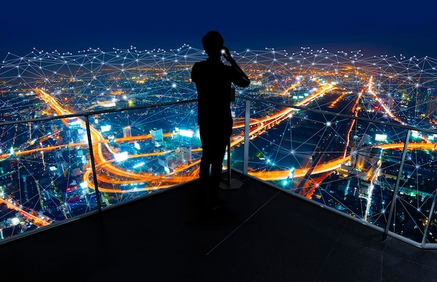 Businessman standing using smart phone watching city viewBusiness Wireless network and Connection