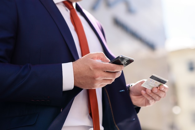 Photo businessman works with credit card and telephone