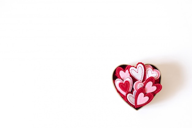 Cardboard box in the form of a heart with different hearts inside on light