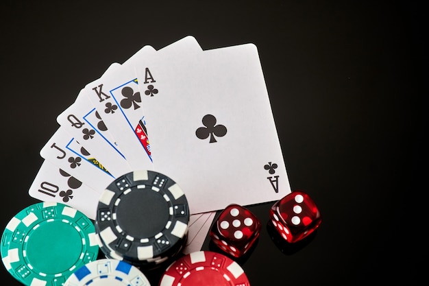 Casino chips playing cards and dices on dark reflective background