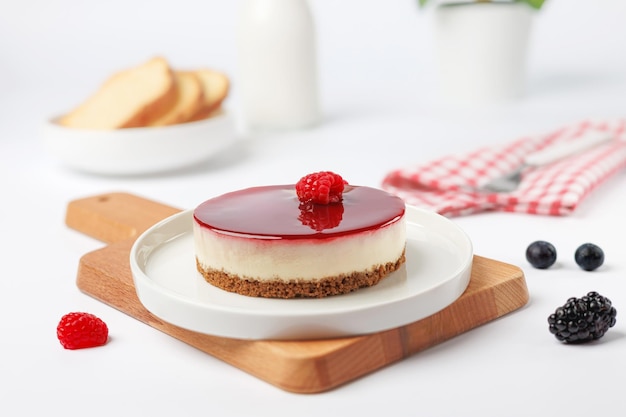 Photo cheesecake with raspberries on a white plate on a white background