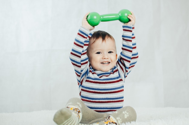 The child is involved in sports, fitness lifting dumbbell