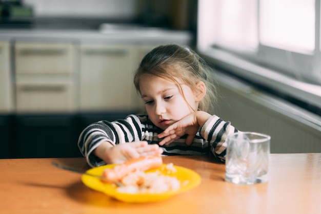 the child refuses to eat, and hands pushes the dish