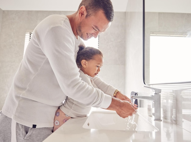 Photo children cleaning and family with a man and girl washing their hands in the bathroom at home together kids water and hygiene with a father teaching his daughter about clean and healthy living