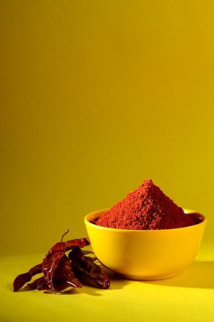 Chili powder in yellow bowl. Red chilly pepper