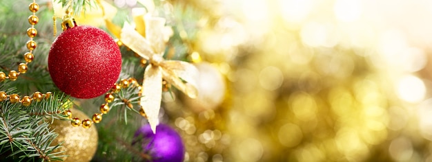 Christmas background. Christmas tree decorated with colorful balls on branch of fir on blurred background