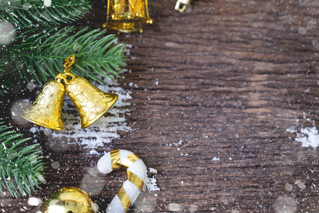 Christmas Decorations with gold bell and Leafs frame on wooden table.