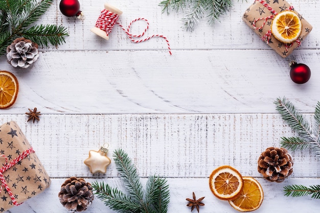 Christmas with fir branches, pinecones, gift box, dried oranges, star anise and berries